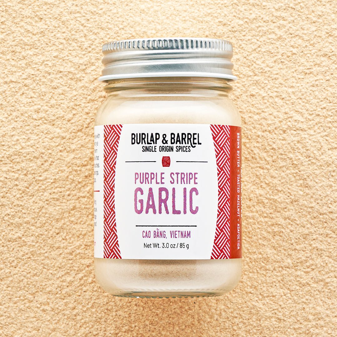 Jar of Purple Stripe Garlic from Burlap & Barrel on a beige background