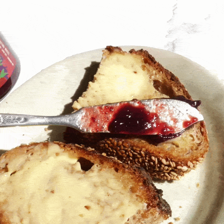 butter knife spreading preserves on buttered toast