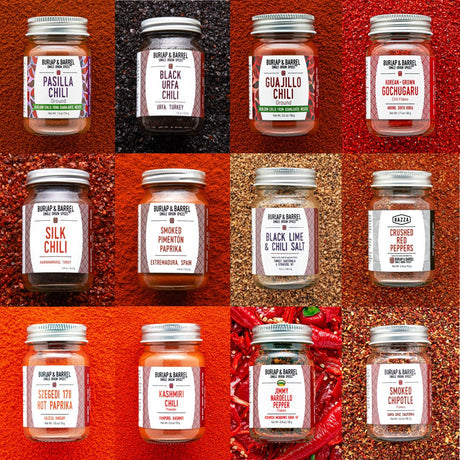 Jars of Burlap & Barrel chilis on multi-colored background of loose chili flakes