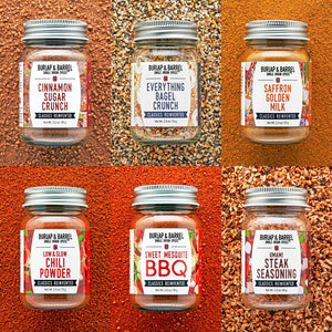 Jars of Burlap & Barrel seasoning mixes on a textured orange background