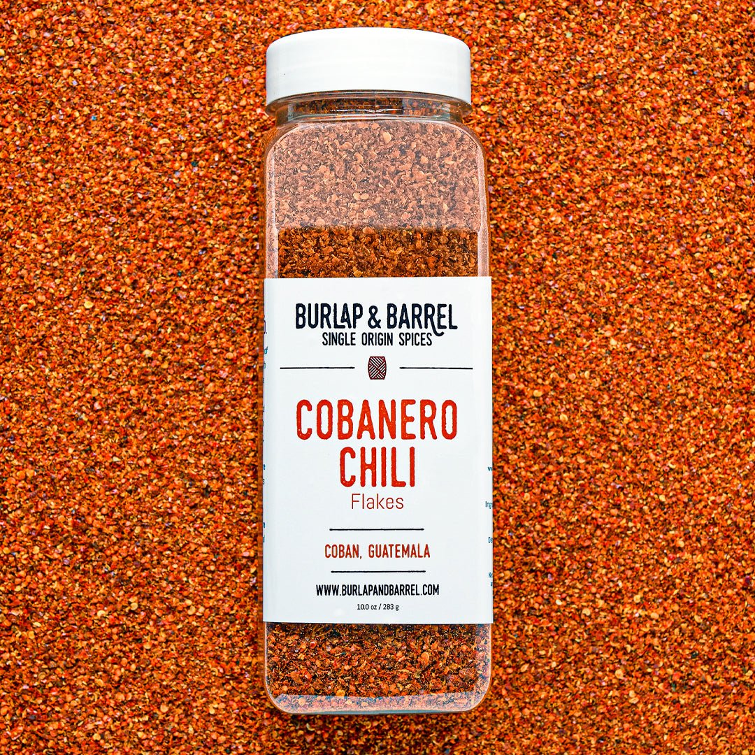 Burlap & Barrel Cobanero Chili Flakes jar against a background of Cobanero flakes