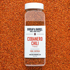 Burlap & Barrel Cobanero Chili Flakes jar against a background of Cobanero flakes
