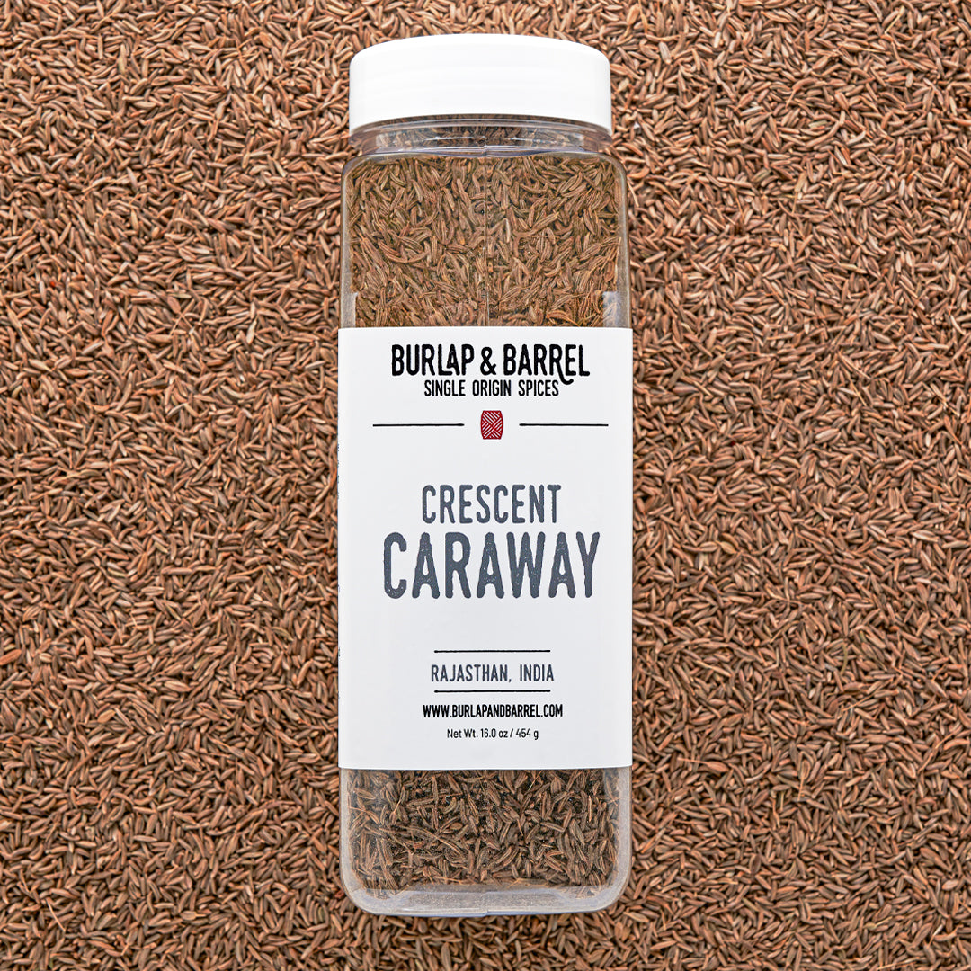Bottle of Burlap & Barrel Crescent Caraway on a caraway seed background from Burlap & Barrel