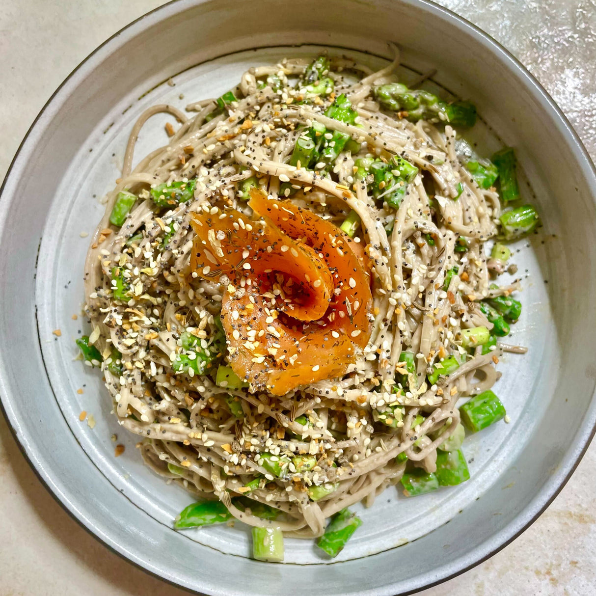 Sesame noodles with vegetables and a sauce with Everything Bagel on a light surface
