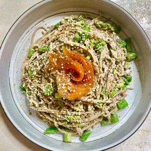 Sesame noodles with vegetables and a sauce with Everything Bagel on a light surface