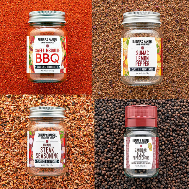 Four jars of Burlap & Barrel spices on a textured background