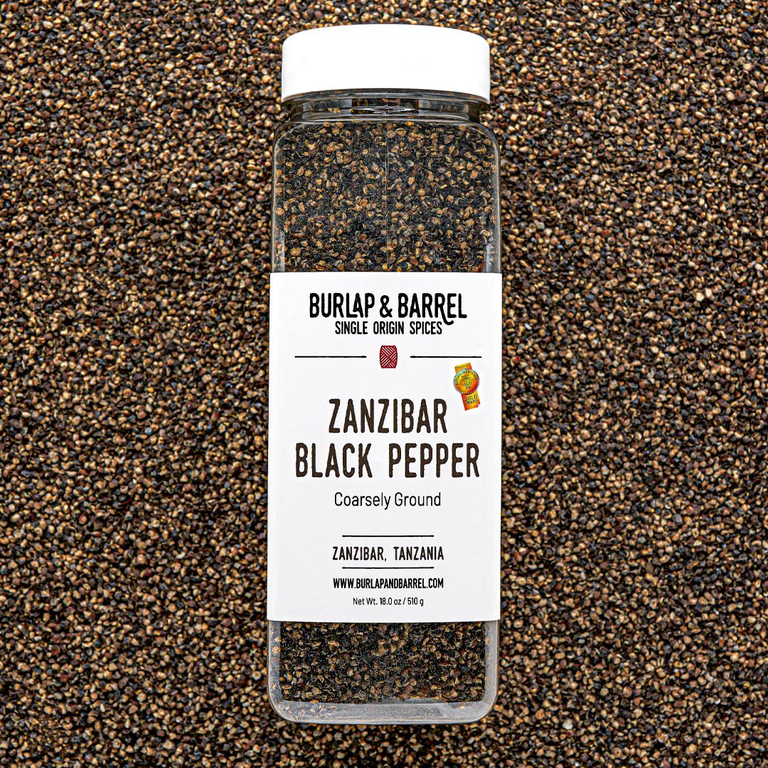Bottle of Burlap & Barrel Zanzibar Black Pepper on a textured black and brown background
