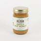 A jar of Big Spoon Roasters Hatch Hot Honey in garlic butter flavor, featuring a white label with green text and a gold metal lid, set against a plain white background.