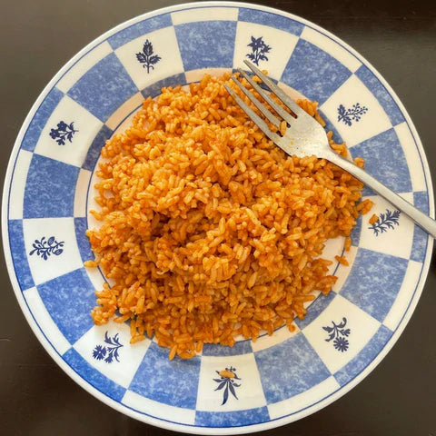 Orange rice on a blue and white checkered plate with a fork