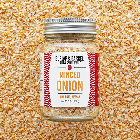 Jar of minced onion spice with 'Burlap & Barrel' label on a textured background