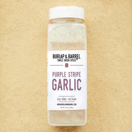 Bottle of Burlap & Barrel Purple Stripe Garlic on a beige background