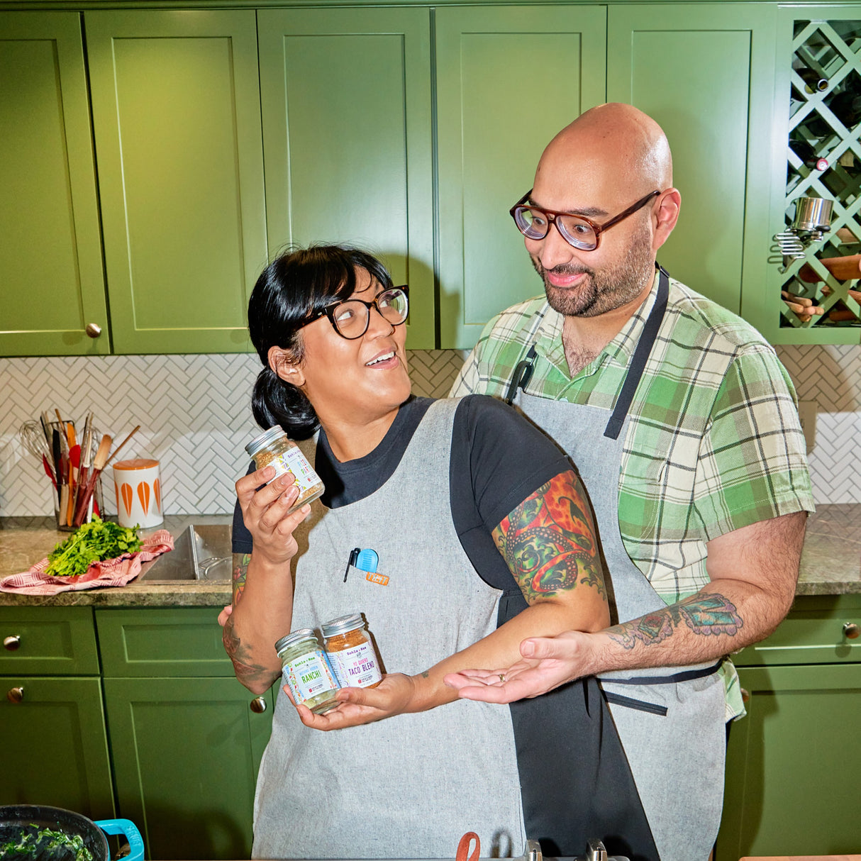 Sohla & Ham El-Waylly with their Burlap & Barrel collaboration spice blends in a green kitchen. 