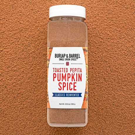 Container of Burlap & Barrel Toasted Pepita Pumpkin Spice on a brown background