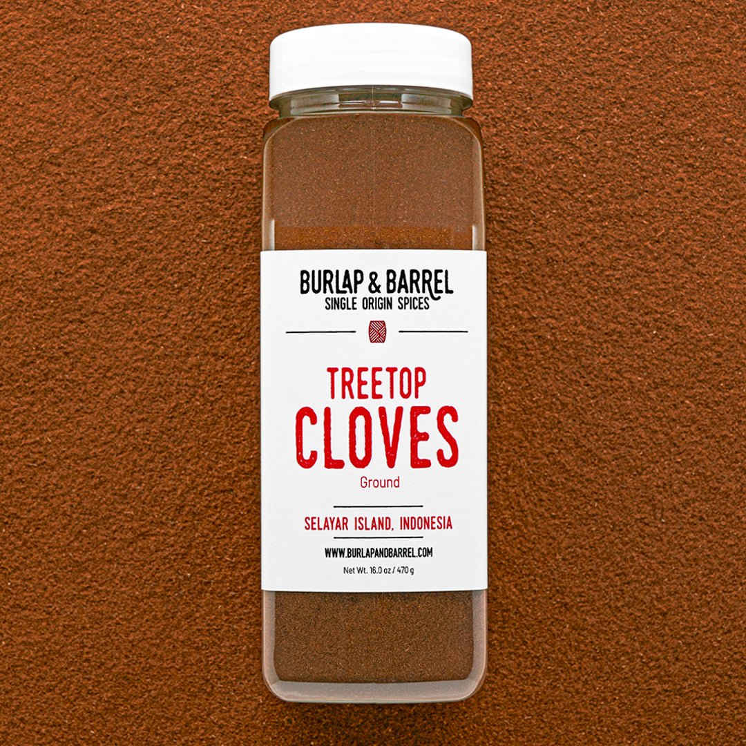 Container of Burlap & Barrel Treetop Cloves on a brown background