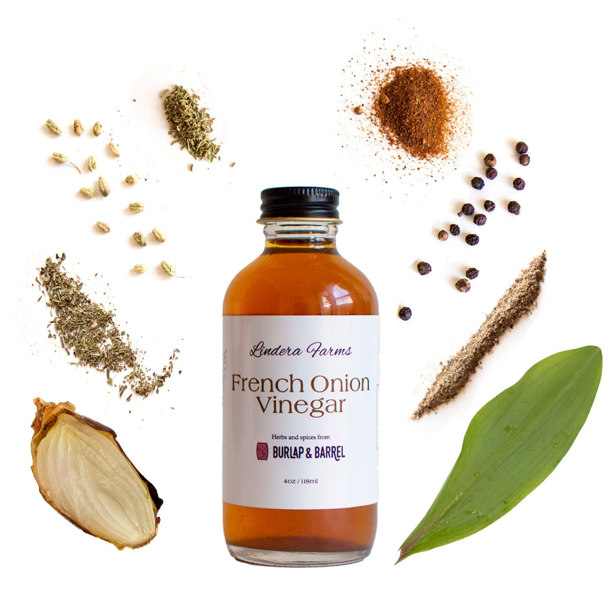 Lindera Farms French Onion Vinegar bottle surrounded by ingredient components including onion, herbs, spices, and juniper berries.