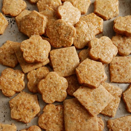 Cookies in various flower and diamond shapes with golden crystal sugar sprinkled over the top.