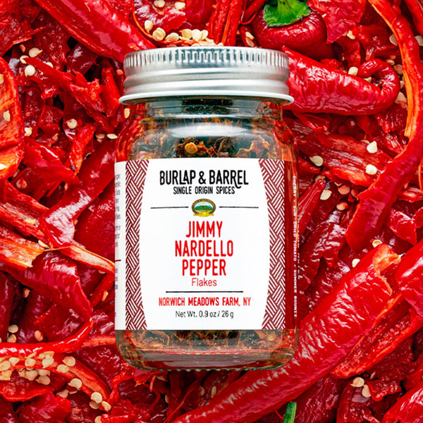 Jimmy Nardello Pepper Flakes jar by Burlap & Barrel on bed of red peppers