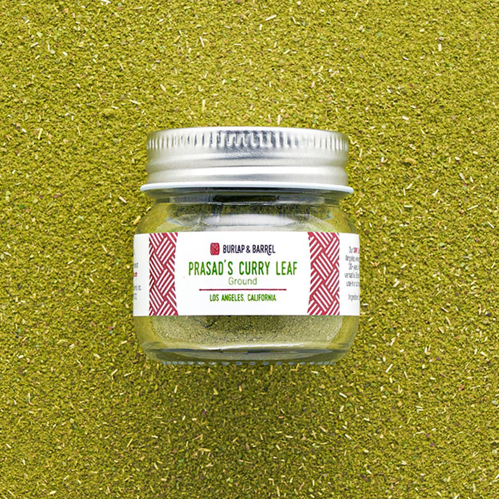 Burlap & Barrel Prasad's Curry Leaf Ground spice jar with silver lid on green textured background
