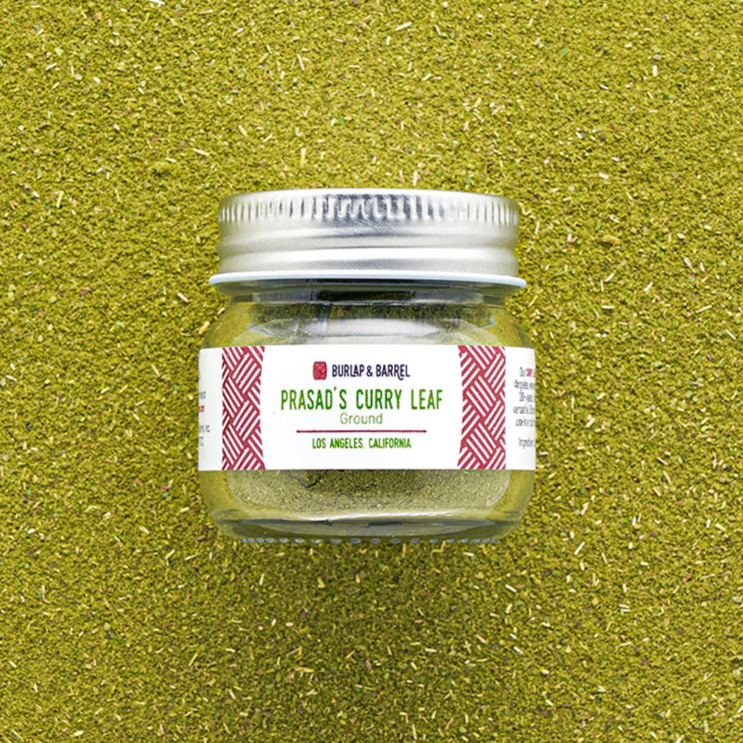 Burlap & Barrel Prasad's Curry Leaf Ground spice jar with silver lid on green textured background