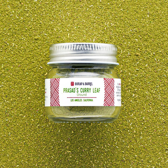 Burlap & Barrel Prasad's Curry Leaf Ground spice jar with silver lid on green textured background